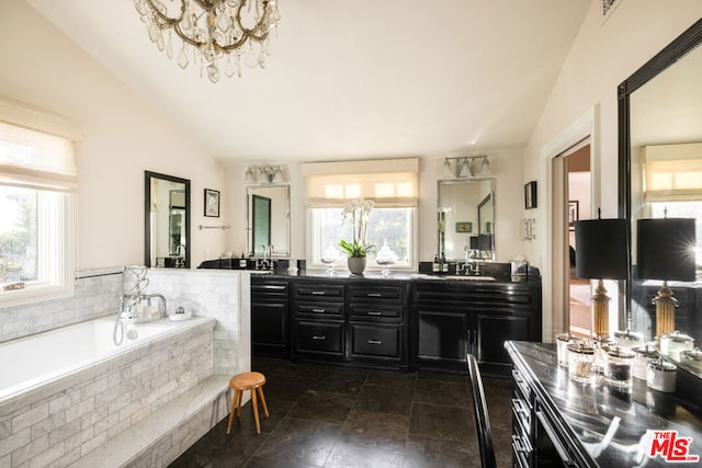 bathroom with tiled tub, vanity, and lofted ceiling