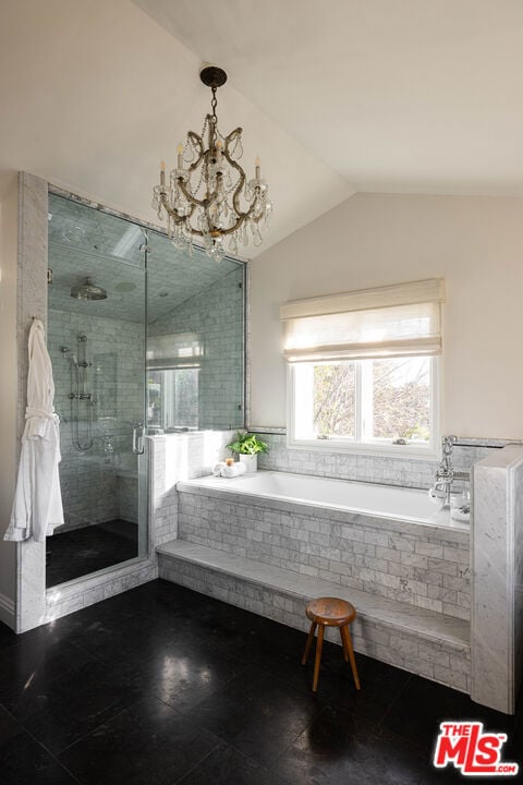 bathroom with lofted ceiling, shower with separate bathtub, and an inviting chandelier