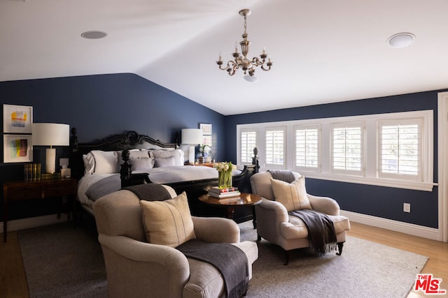 bedroom with lofted ceiling, a notable chandelier, and light hardwood / wood-style floors