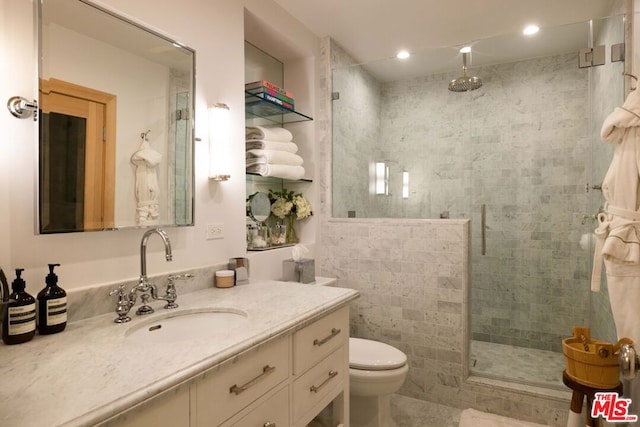 bathroom featuring vanity, toilet, and walk in shower