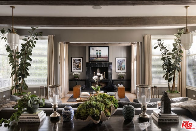 living room featuring a premium fireplace and beam ceiling