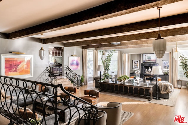 living room featuring a fireplace, light hardwood / wood-style flooring, and beamed ceiling