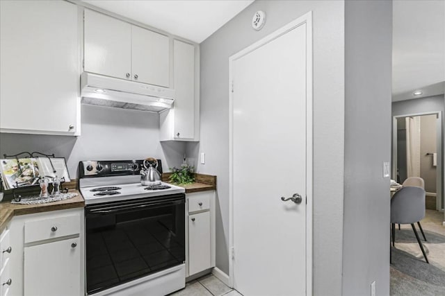 kitchen with light tile patterned flooring, electric range oven, and white cabinets