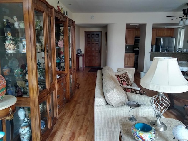 living room featuring ceiling fan and light hardwood / wood-style floors