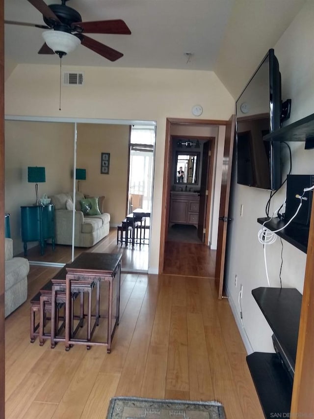 interior space featuring light hardwood / wood-style flooring, vaulted ceiling, and ceiling fan