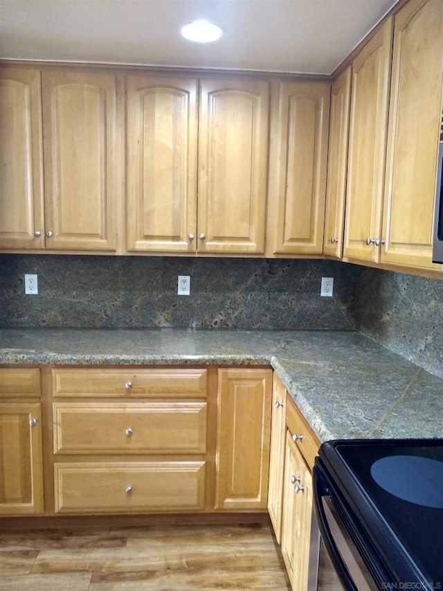 kitchen featuring tasteful backsplash, electric range, light hardwood / wood-style floors, and light brown cabinets