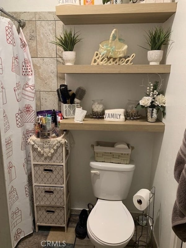 bathroom featuring a shower with shower curtain and toilet