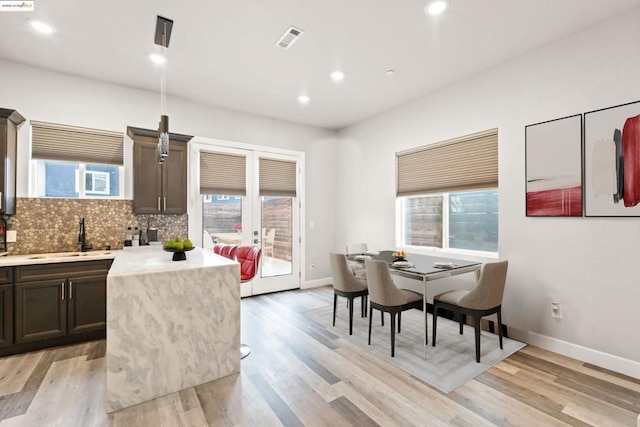 dining room with plenty of natural light, sink, and light hardwood / wood-style floors