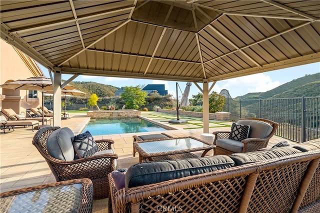 view of patio with fence, a mountain view, and a gazebo