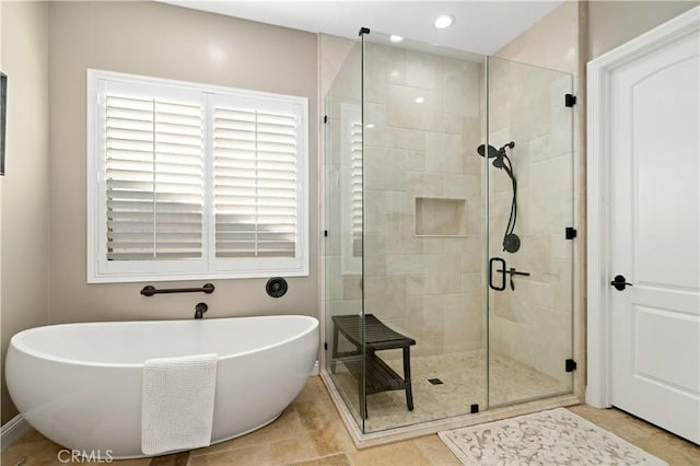 full bath featuring recessed lighting, a freestanding bath, a shower stall, and tile patterned floors