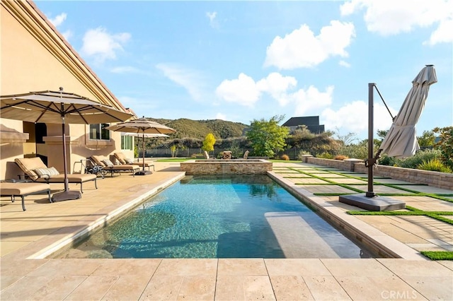 view of swimming pool featuring a patio and a pool with connected hot tub