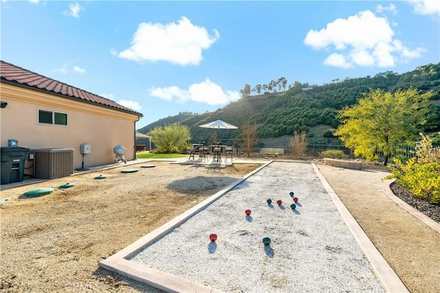 view of yard with cooling unit, a mountain view, and fence