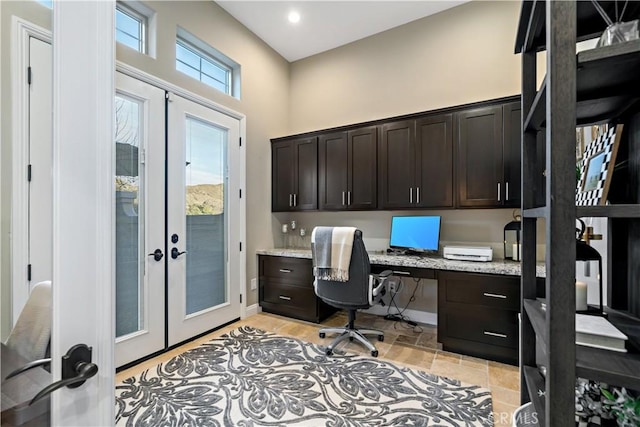 office with a high ceiling, baseboards, built in desk, and french doors