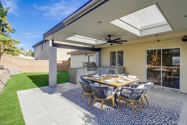 view of patio / terrace with ceiling fan, grilling area, and exterior kitchen