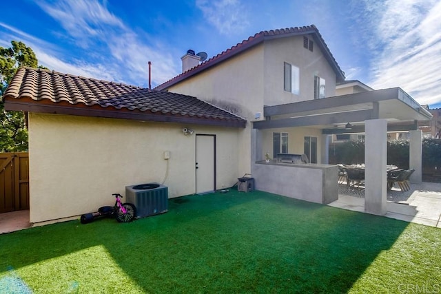 back of house with exterior kitchen, central air condition unit, a patio area, and a lawn