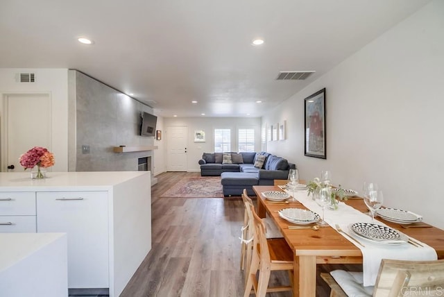 dining space with a fireplace and light hardwood / wood-style floors