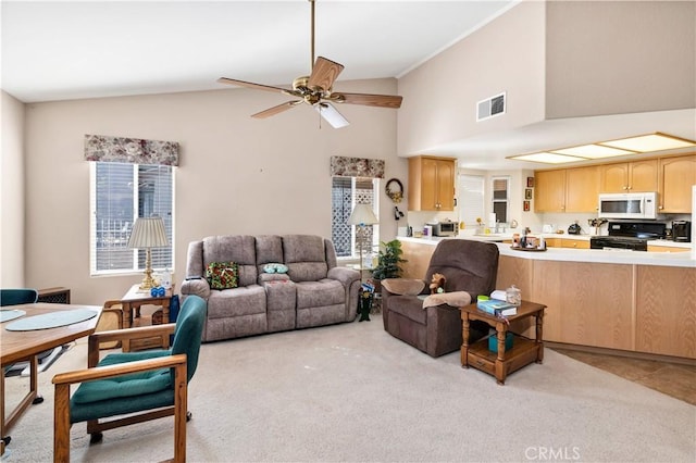 living room with ceiling fan, high vaulted ceiling, light carpet, and a wealth of natural light