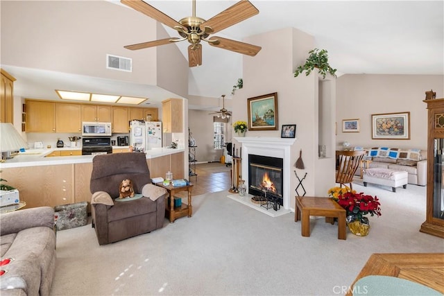 living room featuring ceiling fan, light colored carpet, and high vaulted ceiling