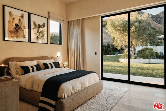 bedroom with access to outside and light hardwood / wood-style flooring