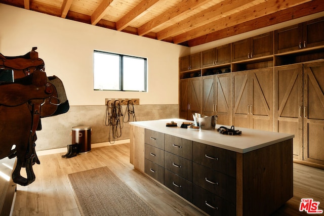 interior space featuring beamed ceiling and light hardwood / wood-style flooring