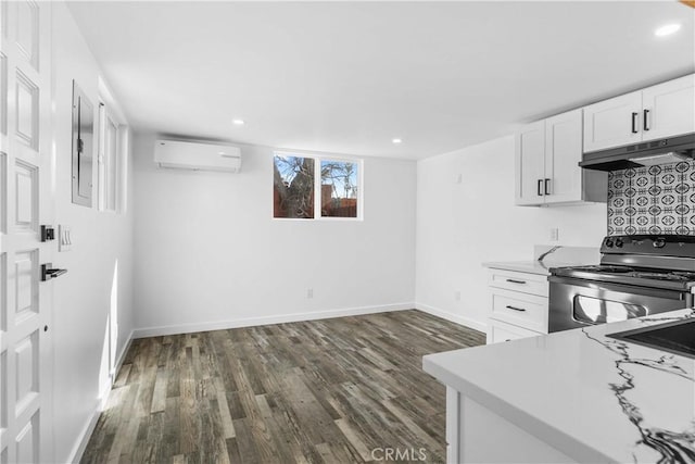 kitchen with black electric range oven, a wall mounted air conditioner, dark hardwood / wood-style floors, and white cabinets