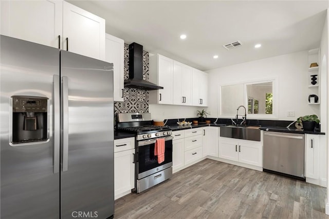 kitchen featuring sink, stainless steel appliances, white cabinets, wall chimney exhaust hood, and light wood-type flooring