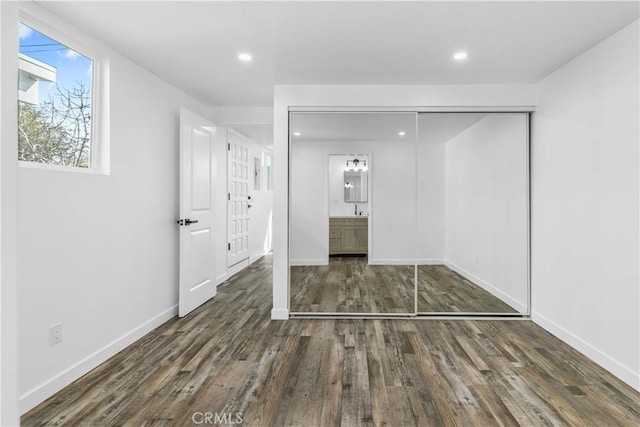 unfurnished bedroom with dark hardwood / wood-style flooring and a closet