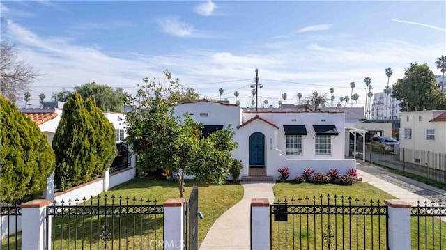 mediterranean / spanish home with a front lawn