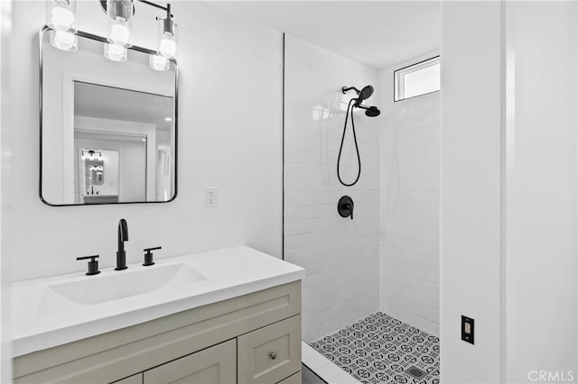 bathroom with vanity and a tile shower