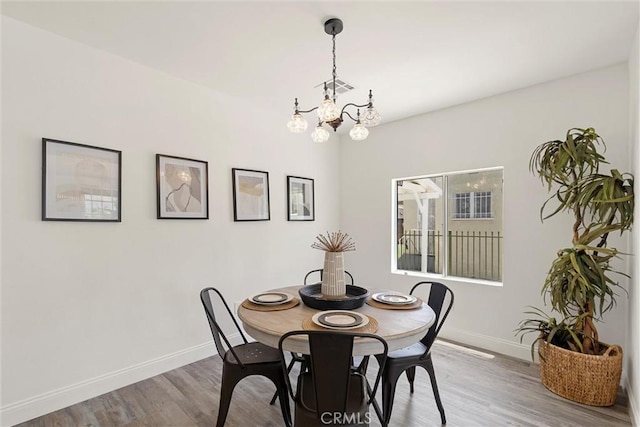 dining area featuring hardwood / wood-style flooring and a chandelier