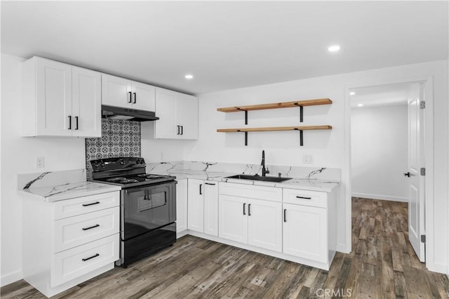 kitchen with black / electric stove, light stone countertops, sink, and white cabinets