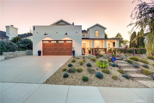 view of front of property featuring concrete driveway, fence, and an attached garage