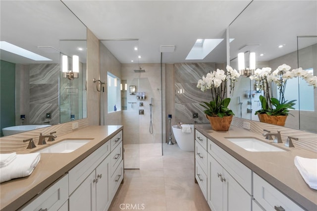 bathroom featuring tile walls, vanity, a skylight, and separate shower and tub