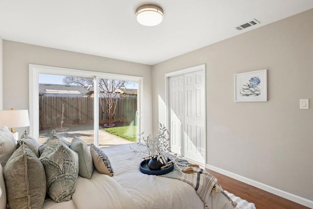 bedroom with hardwood / wood-style floors, access to exterior, and a closet