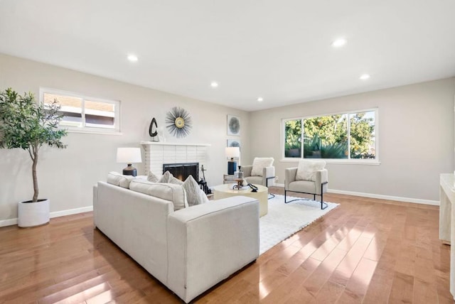 living room with light hardwood / wood-style floors and a brick fireplace