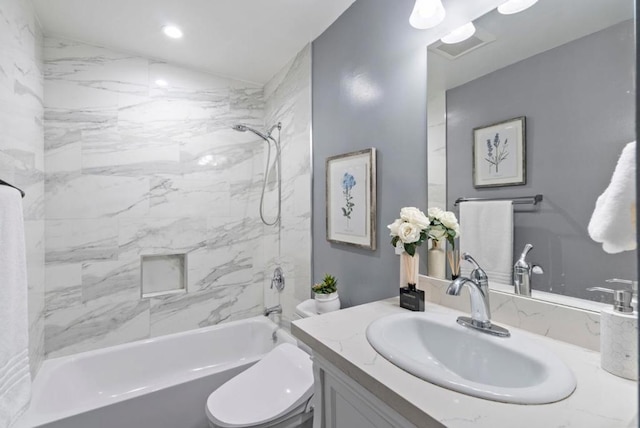 full bathroom featuring vanity, tiled shower / bath combo, and toilet