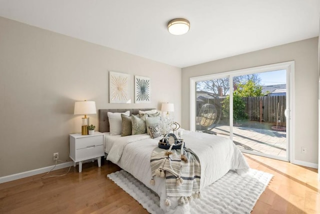 bedroom with hardwood / wood-style floors and access to outside