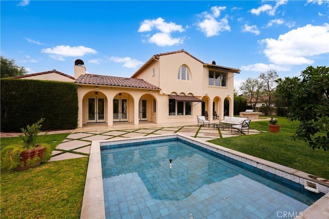 rear view of property featuring a lawn and a patio area