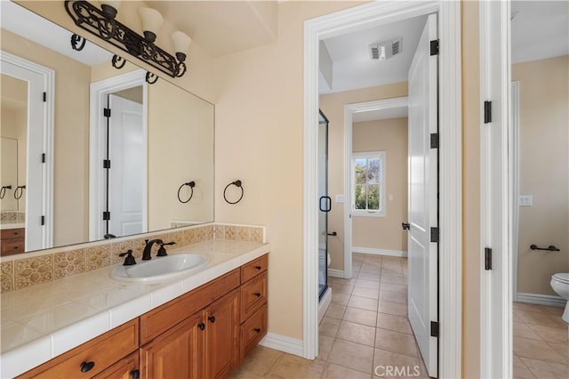 bathroom featuring tile patterned flooring, vanity, and toilet