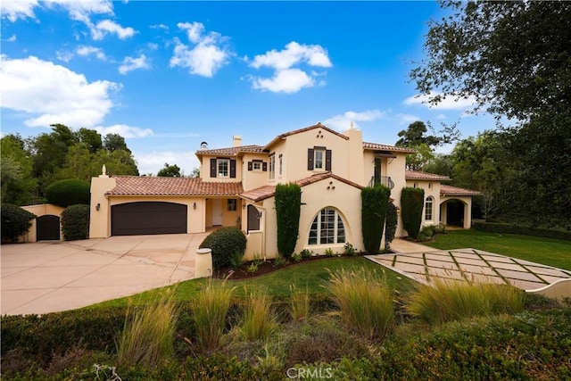 mediterranean / spanish-style home featuring a garage and a front yard