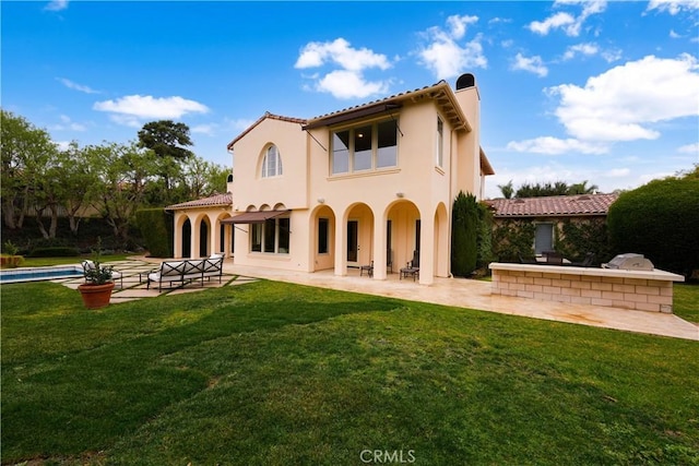 back of property with a yard and a patio area