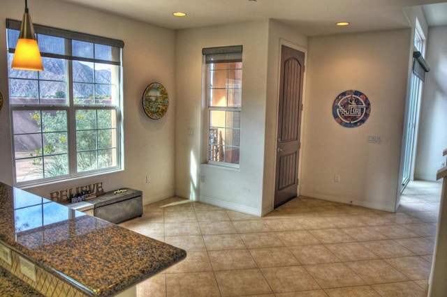 kitchen with dark stone counters and light tile patterned flooring