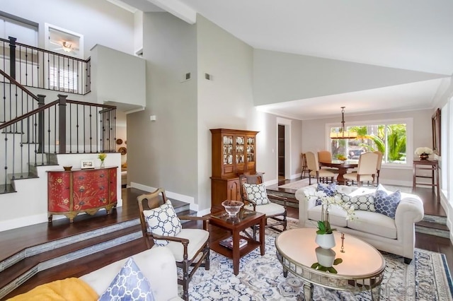 living room with crown molding, wood-type flooring, high vaulted ceiling, and a notable chandelier