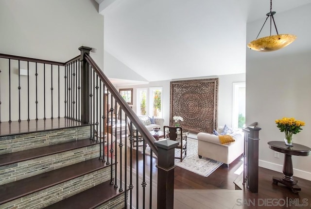 staircase featuring a high ceiling and wood-type flooring