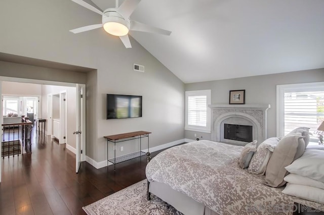 bedroom featuring dark wood-type flooring, ceiling fan, high vaulted ceiling, and multiple windows