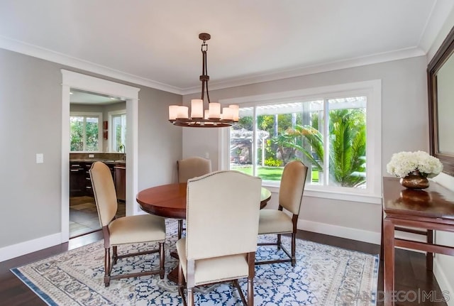 dining space featuring an inviting chandelier, ornamental molding, plenty of natural light, and dark wood-type flooring