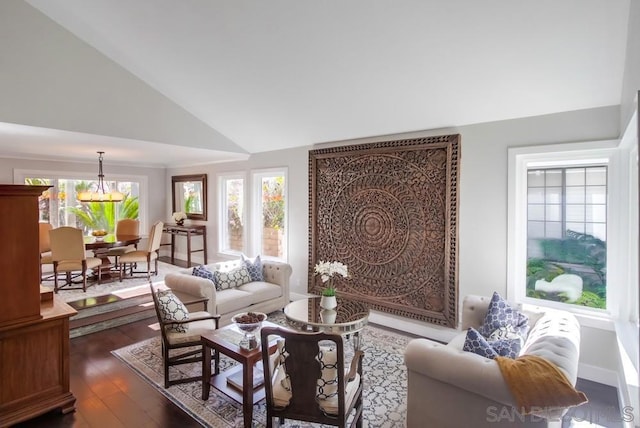 living room with an inviting chandelier, dark wood-type flooring, and vaulted ceiling