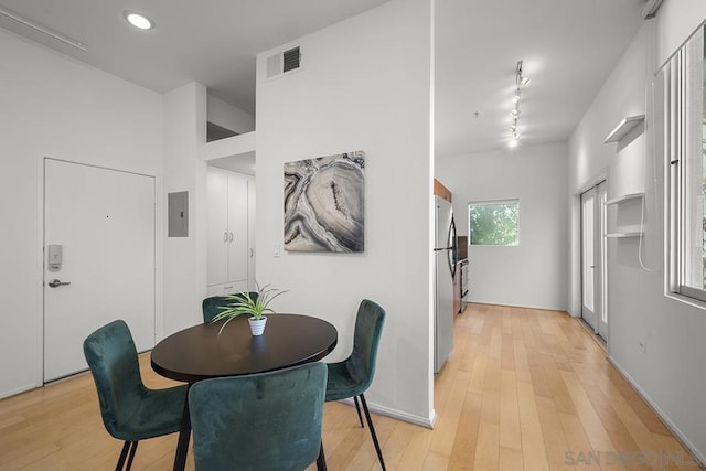 dining space featuring electric panel and light hardwood / wood-style floors