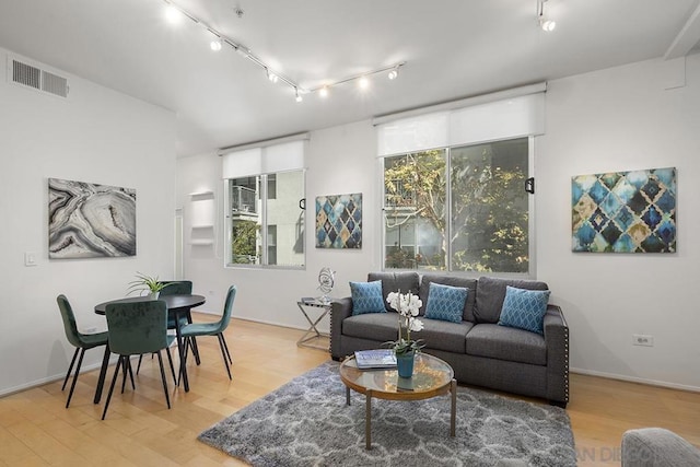 living room with rail lighting and light hardwood / wood-style flooring