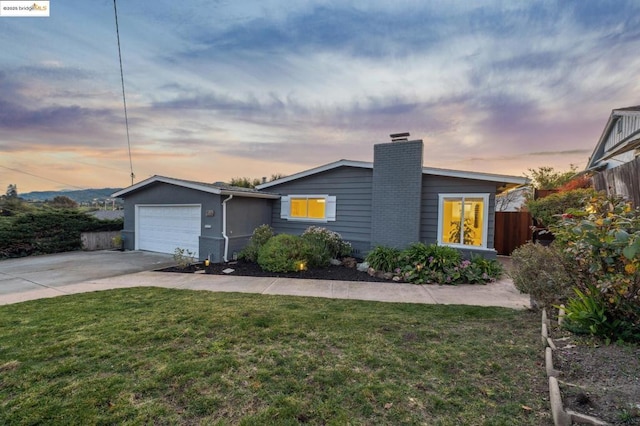 single story home with a garage and a yard